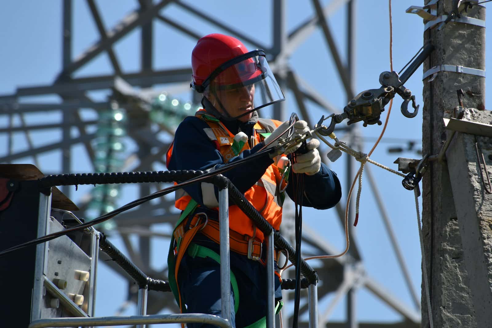 An electrician working on a steel cable