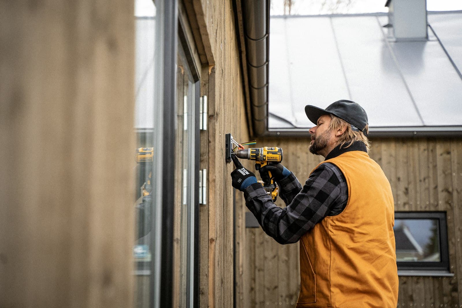 Electrician in a hard hat using a drill
